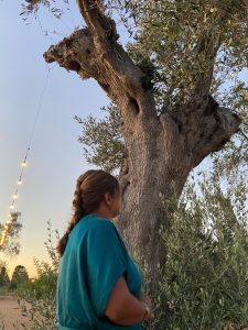 Dr. Femida Gwadry-Sridhar glancing up at an olive tree in Italy